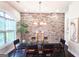 Elegant dining room with a glass table, modern chairs, stylish lighting, and a decorative brick accent wall at 4107 Township Pkwy # 69, Sandy Springs, GA 30342