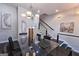 Contemporary dining room featuring modern light fixture, glass-top table, and artwork, adjacent to open staircase at 4107 Township Pkwy # 69, Sandy Springs, GA 30342