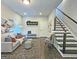 Inviting living room featuring a sofa, patterned ottomans, and staircase access, with ample natural light at 4107 Township Pkwy # 69, Sandy Springs, GA 30342