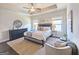 Bright main bedroom featuring a tray ceiling, ceiling fan, dark wood floors, a dresser, and windows at 4107 Township Pkwy # 69, Sandy Springs, GA 30342