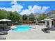 Community pool with lounge chairs, umbrellas, pergolas and clubhouse at 4107 Township Pkwy # 69, Sandy Springs, GA 30342