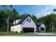 Charming white brick home with a two-car garage and beautifully landscaped front yard on a sunny day at 1077 Crooked Creek Rd, Lithonia, GA 30058