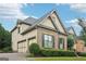 View of the side of a 2-story home with a 3-car garage, brick and siding, and manicured shrubs at 2452 Stone Manor Ne Dr, Buford, GA 30519