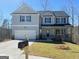 Charming two-story home featuring a manicured lawn, attached garage, and classic architectural details at 5342 Legacy Trl # 30, Douglasville, GA 30135