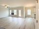 Open-concept living area with light wood floors, fireplace, ceiling fan, and natural light at 5342 Legacy Trl # 30, Douglasville, GA 30135
