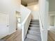 Bright foyer showcasing a staircase with carpeted steps and neutral walls and light wood floors at 5342 Legacy Trl # 30, Douglasville, GA 30135
