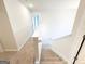Carpeted staircase with white banister leading to a hallway with open doorway at 5342 Legacy Trl # 30, Douglasville, GA 30135