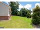 A spacious backyard features lush green grass and various trees at 7301 Cranleigh St, Covington, GA 30014