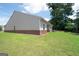 A spacious backyard features a brick foundation and lush green grass at 7301 Cranleigh St, Covington, GA 30014