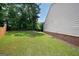 A spacious backyard features lush green grass, various trees and a partial view of the house at 7301 Cranleigh St, Covington, GA 30014