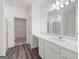 A bathroom featuring a shower and sink with white cabinets, light walls, and wood-look flooring at 7301 Cranleigh St, Covington, GA 30014
