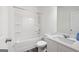 Bright bathroom featuring a white vanity, toilet, and tub with shower, complemented by modern fixtures and dark wood floor at 7301 Cranleigh St, Covington, GA 30014