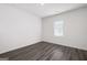 A bright and airy room with gray wood-look flooring and white walls is illuminated by a window at 7301 Cranleigh St, Covington, GA 30014