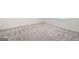 An empty bedroom has neutral-colored carpet and white baseboards with light neutral walls at 7301 Cranleigh St, Covington, GA 30014
