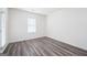 Minimalist bedroom with wood-look flooring, bright white walls and a window with natural light at 7301 Cranleigh St, Covington, GA 30014