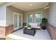 Stylish covered patio featuring a modern sofa, coffee table, and potted plants at 7301 Cranleigh St, Covington, GA 30014