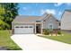 Charming single-Gathering home featuring a two-car garage, red brick accents, and a well-manicured front yard at 7301 Cranleigh St, Covington, GA 30014