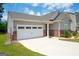 Charming single-Gathering home featuring a two-car garage, red brick accents, and a well-manicured front yard at 7301 Cranleigh St, Covington, GA 30014