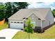 Charming exterior view featuring a two-car garage, a light-colored exterior, and a well-manicured lawn at 7301 Cranleigh St, Covington, GA 30014