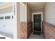 Close-up of home's front door, red brick accents, house number and a 'welcome' mat at 7301 Cranleigh St, Covington, GA 30014