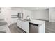 Open-concept kitchen with stainless steel appliances, a granite island, and wood-look flooring flowing into the living area at 7301 Cranleigh St, Covington, GA 30014