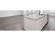 Kitchen island with granite countertop and stainless steel sink, complemented by wood-look flooring at 7301 Cranleigh St, Covington, GA 30014