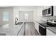 Contemporary kitchen design with stainless steel appliances and an island with granite countertops and a stainless steel sink at 7301 Cranleigh St, Covington, GA 30014