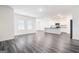 Bright, open-concept living area with wood-look floors, modern kitchen, and large windows at 7301 Cranleigh St, Covington, GA 30014