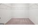 A walk-in closet includes wire shelving and neutral-colored carpet and light neutral walls at 7301 Cranleigh St, Covington, GA 30014
