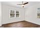 Bright bedroom featuring hardwood floors, a ceiling fan and natural light from two windows at 4178 Castle Pines Ct, Tucker, GA 30084
