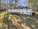 Rear exterior of home showcases a white brick facade, a large backyard and second-story deck at 4178 Castle Pines Ct, Tucker, GA 30084