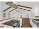 Open kitchen with stainless appliances, granite counters and vaulted wood beam ceiling at 4178 Castle Pines Ct, Tucker, GA 30084