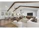 Bright, open-concept living area boasts hardwood floors, vaulted ceilings with wood beams, and modern furnishings at 4178 Castle Pines Ct, Tucker, GA 30084
