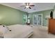 Bedroom featuring a queen bed, a ceiling fan, double doors to a balcony, and green walls at 792 Mimosa Se Dr, Marietta, GA 30060