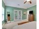 A spacious bedroom with green walls, double doors, a ceiling fan, and neutral carpet at 792 Mimosa Se Dr, Marietta, GA 30060