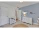 Bedroom with a crib, changing table, dresser, soft rug, and a blue accent wall at 792 Mimosa Se Dr, Marietta, GA 30060