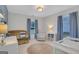 Well-lit Bedroom featuring a crib, comfortable glider chair, and ample natural light from two windows at 792 Mimosa Se Dr, Marietta, GA 30060