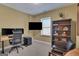 Home office with a modern desk setup, dual monitors, a TV, and a cozy reading area at 792 Mimosa Se Dr, Marietta, GA 30060