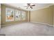 This bright bedroom features three large windows, gray carpeting, and a ceiling fan with a light at 412 Middlebrooke St, Canton, GA 30115