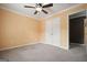 A neutral bedroom featuring gray carpet, double door closet, and a ceiling fan with light fixture at 412 Middlebrooke St, Canton, GA 30115
