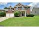Charming brick front exterior with black shutters, an arched window and a two-car garage at 412 Middlebrooke St, Canton, GA 30115