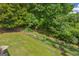 View of a fenced backyard with a small creek and mature trees and foliage at 684 Doe Lane Ln, Loganville, GA 30052