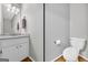 Half bath with white vanity, a marble countertop and hardwood floors at 684 Doe Lane Ln, Loganville, GA 30052