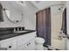 Well-lit bathroom featuring a shower and white vanity with a black countertop at 684 Doe Lane Ln, Loganville, GA 30052