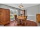 Traditional dining room featuring hardwood floors, a wooden table, and natural light from the large window at 684 Doe Lane Ln, Loganville, GA 30052