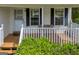 Inviting front porch with bench seating, wood flooring, and white railing at 684 Doe Lane Ln, Loganville, GA 30052