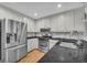 Contemporary kitchen featuring stainless steel appliances, granite countertops, and white cabinetry, offering style and functionality at 684 Doe Lane Ln, Loganville, GA 30052