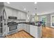 Bright kitchen with white cabinets, stainless steel appliances, and an adjacent dining area, great for entertaining at 684 Doe Lane Ln, Loganville, GA 30052
