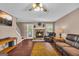 Cozy living room features a stone fireplace, hardwood floors, and a ceiling fan, offering a comfortable retreat at 684 Doe Lane Ln, Loganville, GA 30052