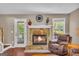 Charming living room featuring a stone fireplace, hardwood floors, and a cozy seating area, ideal for gatherings at 684 Doe Lane Ln, Loganville, GA 30052